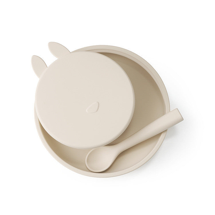 Set of beige bowl, spoon, and lid on a white background