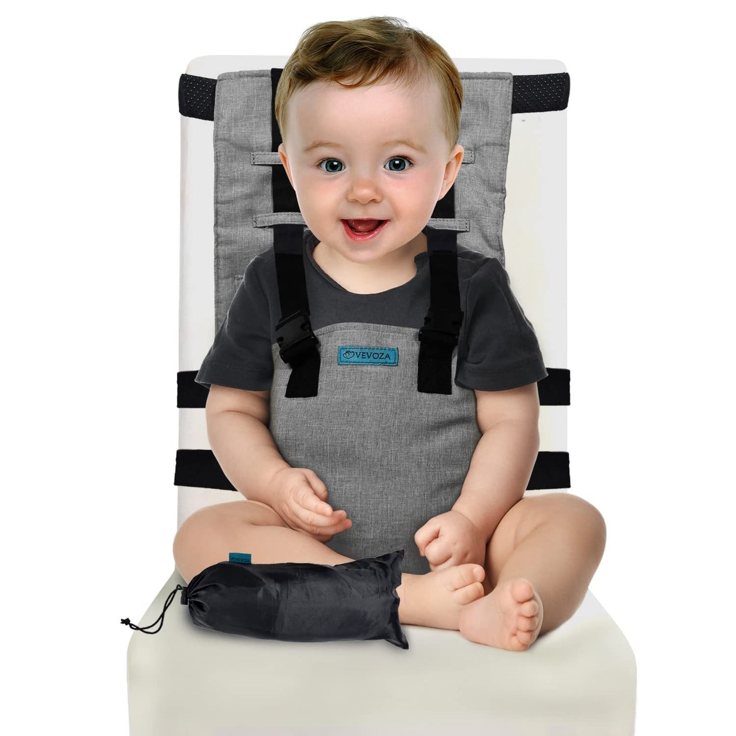 Baby sitting on a gray and black baby seat with a visible brand logo.