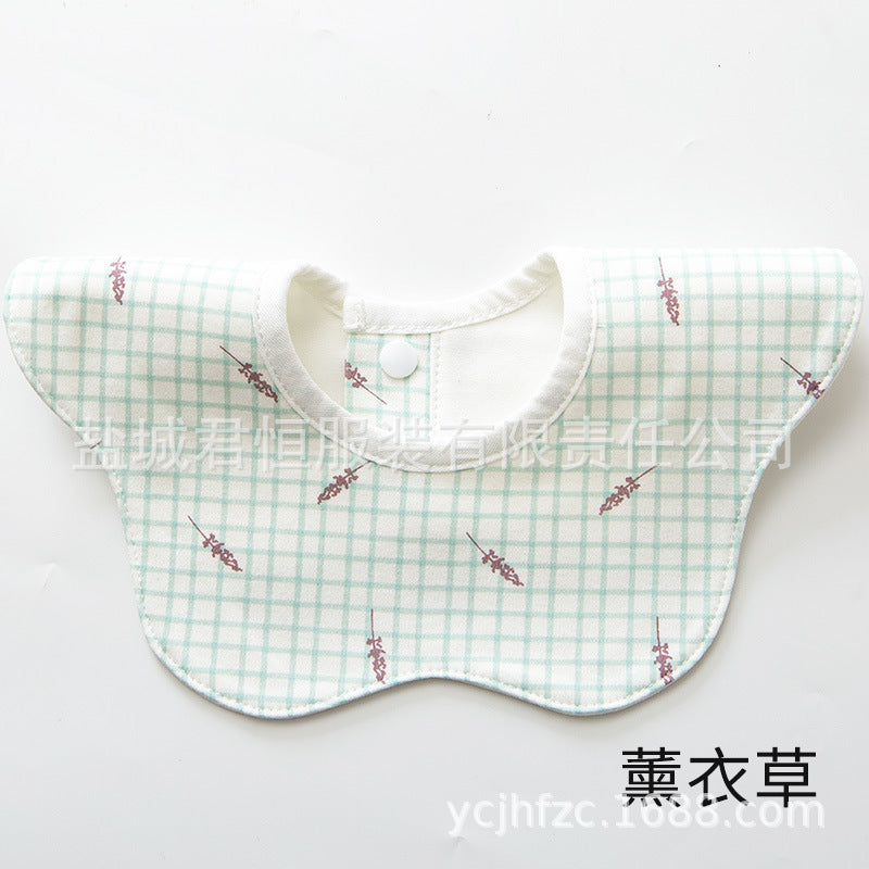 Baby bib with green checkered pattern and floral design on a white background