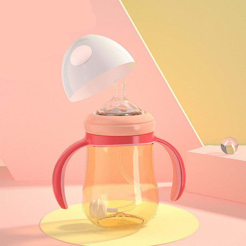 Baby bottle with pink handles on a colorful geometric background
