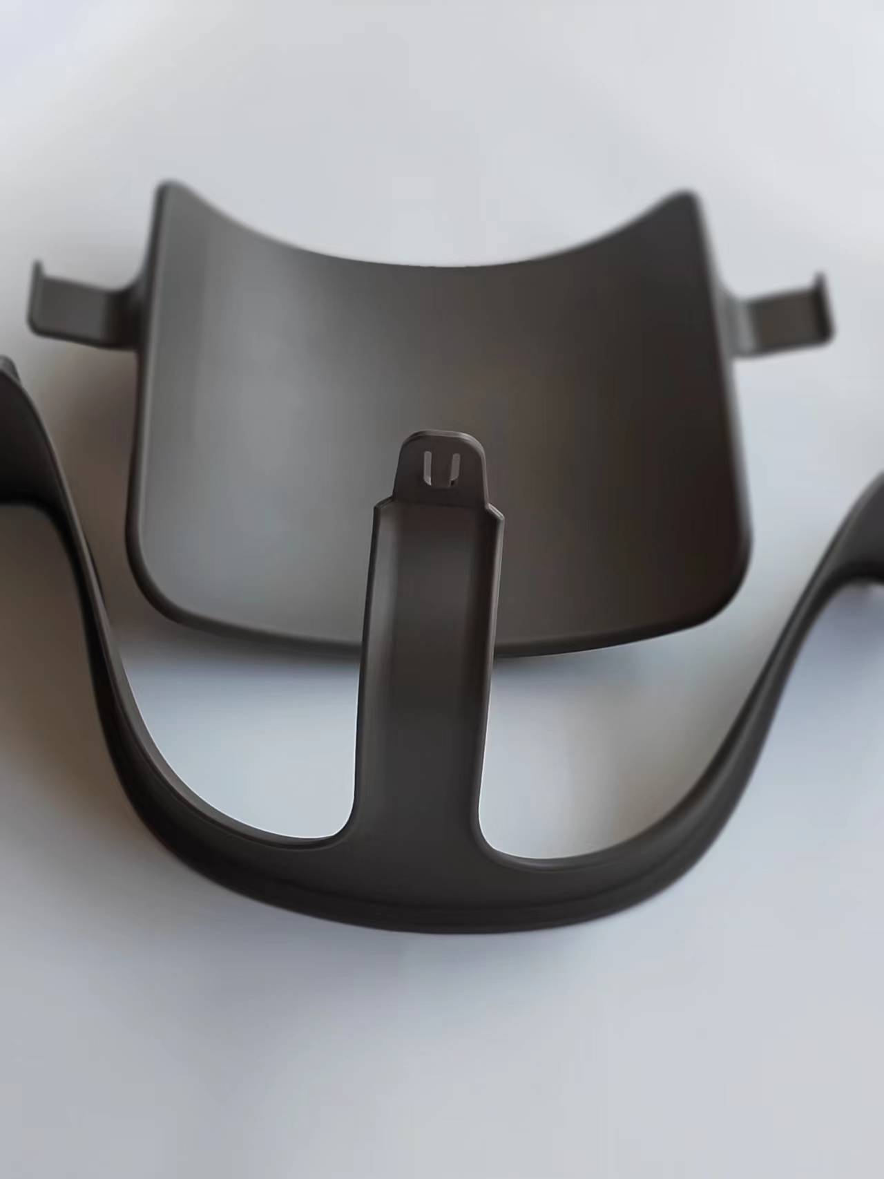 Black plastic component on a white background