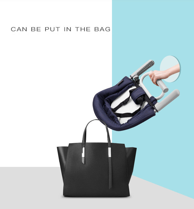 Navy baby seat with white frame being put into a black handbag against a light blue and white background.