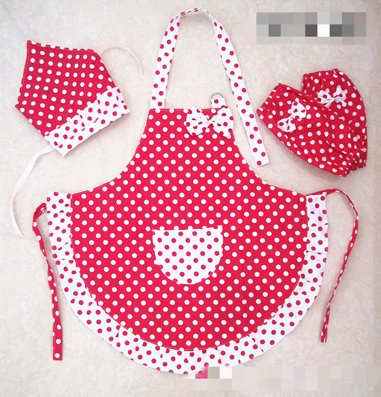 Red and white polka dot apron with matching hat and gloves on a light background