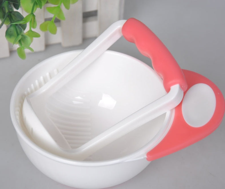 White kitchen tool with red handle on a light gray background