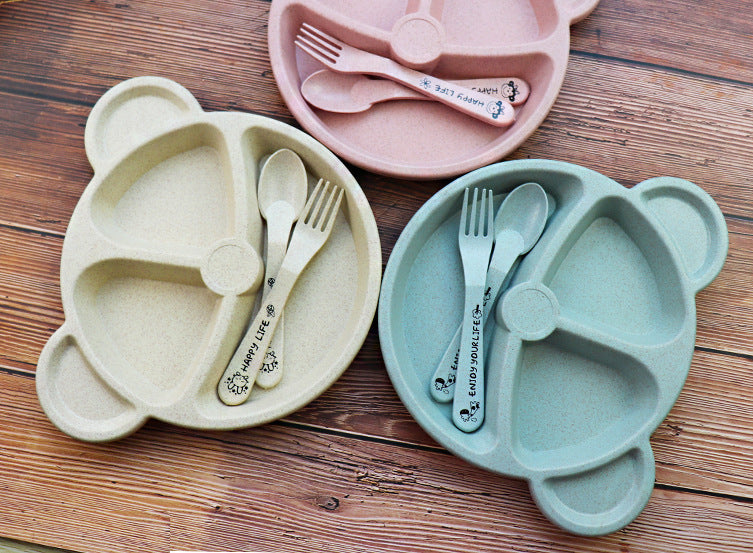 Two bear-shaped plates with cutlery on a wooden surface
