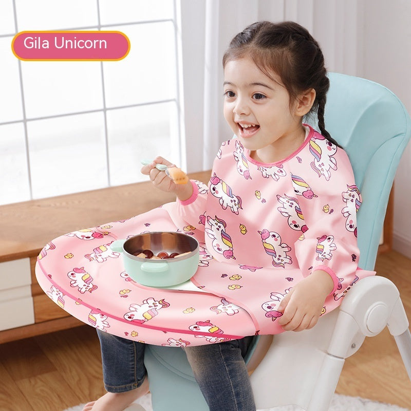 Child wearing a pink unicorn-themed bib sitting on a chair with a tray and bowl.