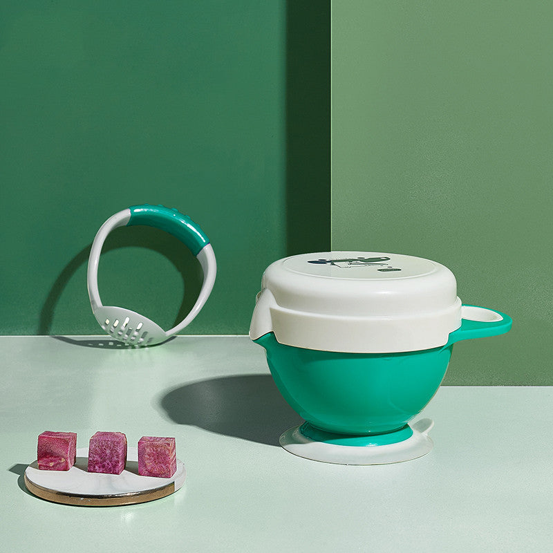 Teal and white kitchen tool on a green background