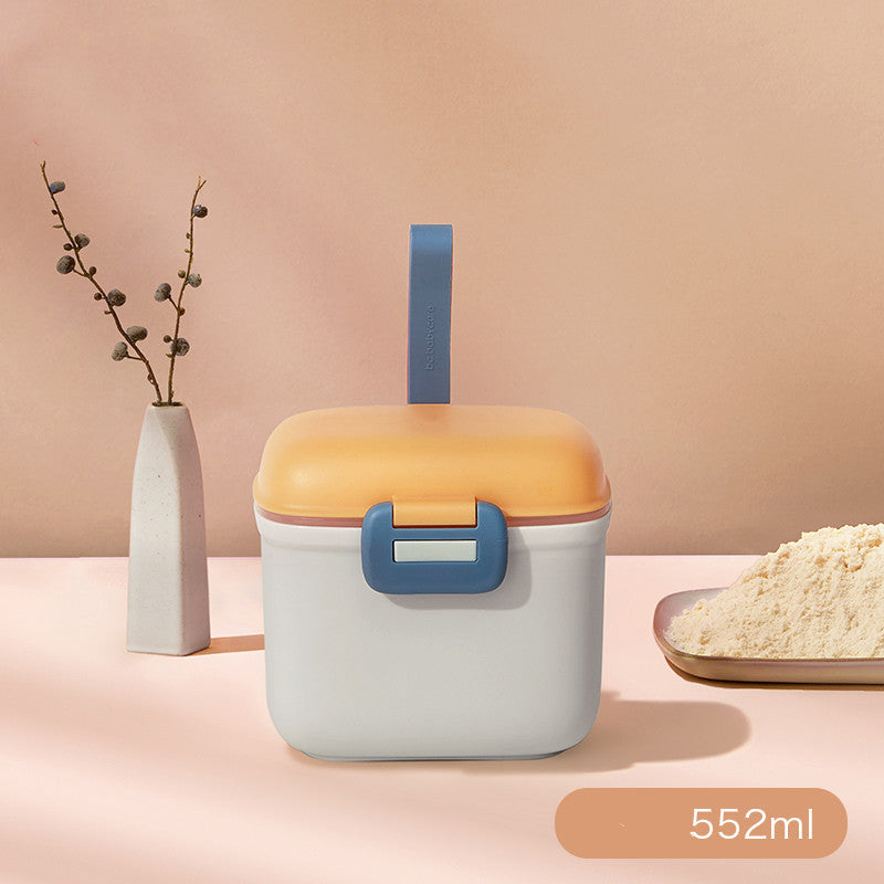 Container with orange lid and blue handles on a pink background