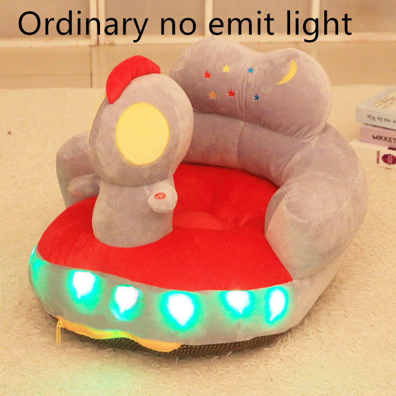Plush toy shaped like a spaceship with glowing lights on a beige surface.