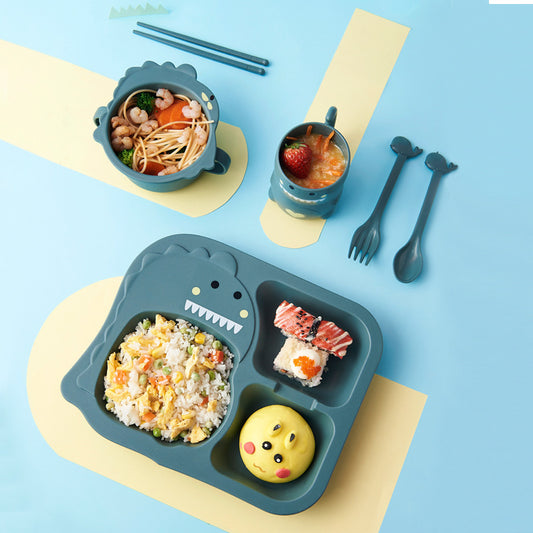 Children's lunch set with dinosaur-shaped tray, bowls, and cutlery on a blue background