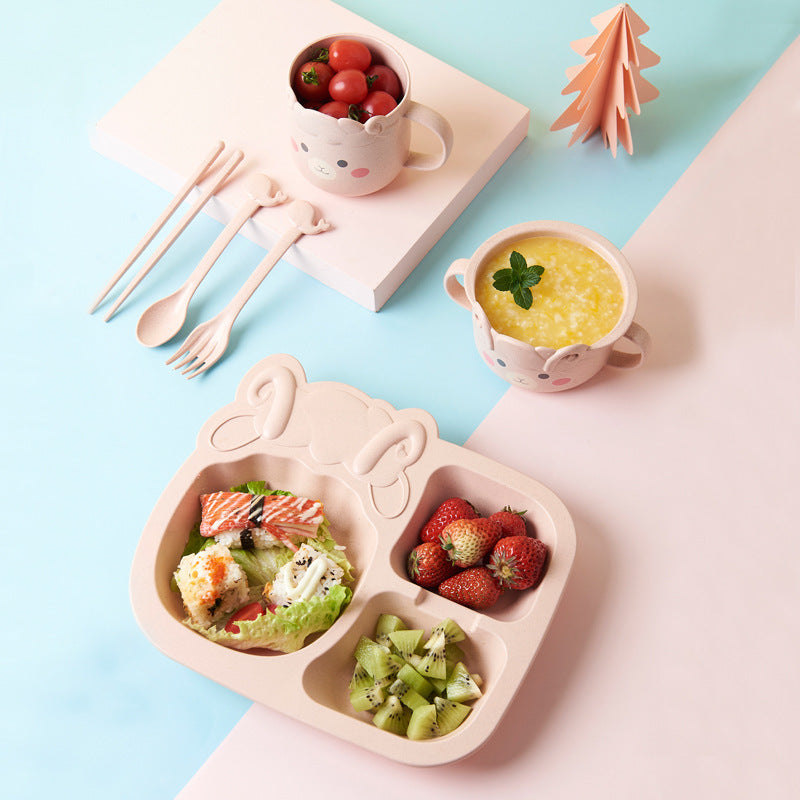 Children's lunch set with divided plate, cups, and utensils on a light blue background