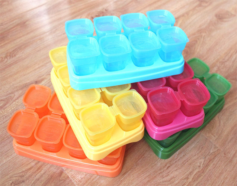 Colorful silicone ice cube trays stacked on a wooden surface