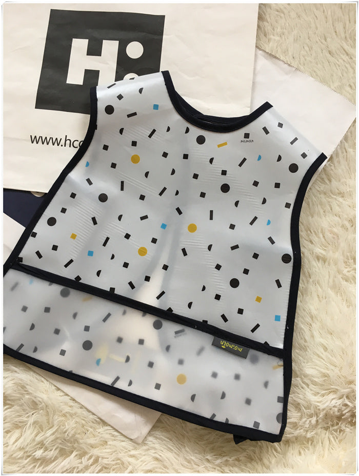 Patterned bib on a fluffy white surface with a blurred background