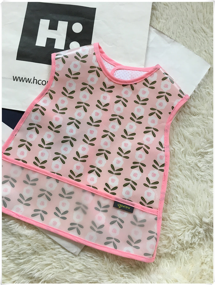Baby bib with floral pattern on a fluffy surface