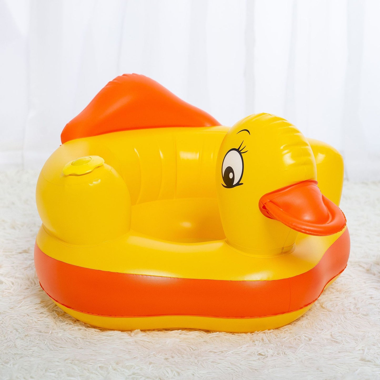 Yellow rubber duck inflatable chair with orange details on a white background
