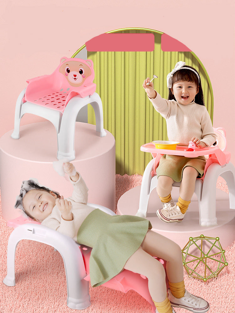 Children sitting on small chairs with pink and green backgrounds