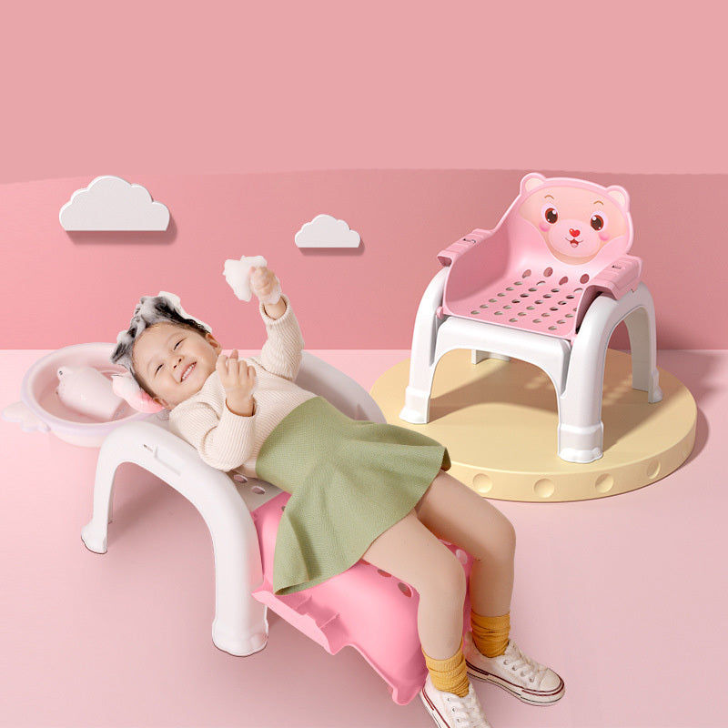 Child sitting on a pink chair with a bear design against a pink background