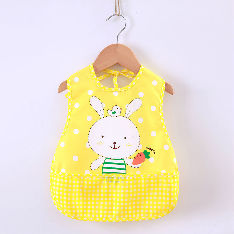 Yellow bib with a cartoon bunny design on a wooden hanger against a white background