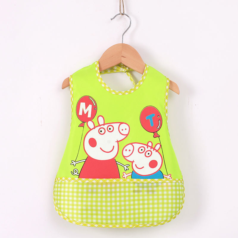 Green bib with cartoon characters hanging on a wooden hanger against a white background