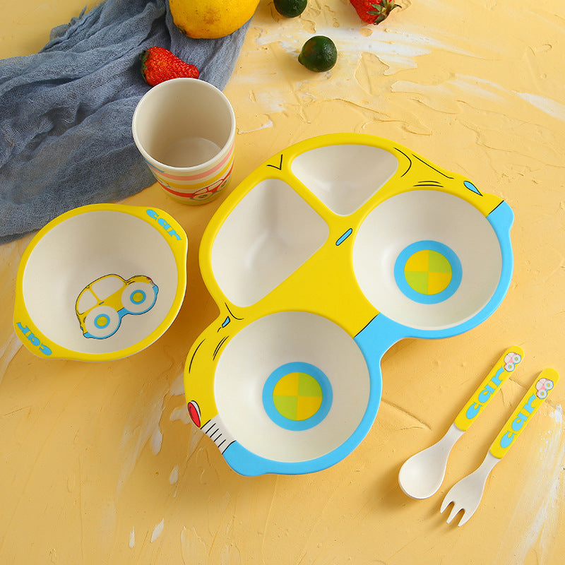 Colorful children's plate set with bowls and cutlery on a yellow surface