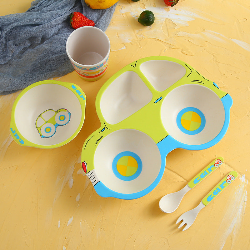 Children's ceramic tableware set with colorful design on a yellow surface