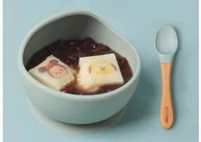 Bowl of dessert with a spoon on a light blue background