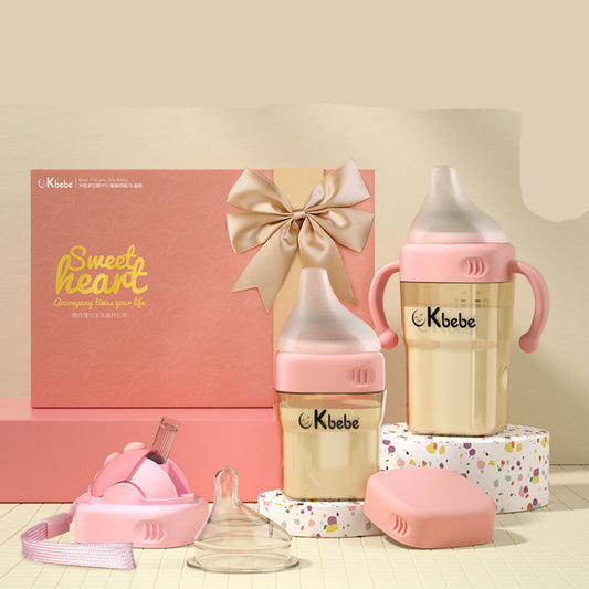 Kbebe baby bottle set with pink and gold elements on a neutral background