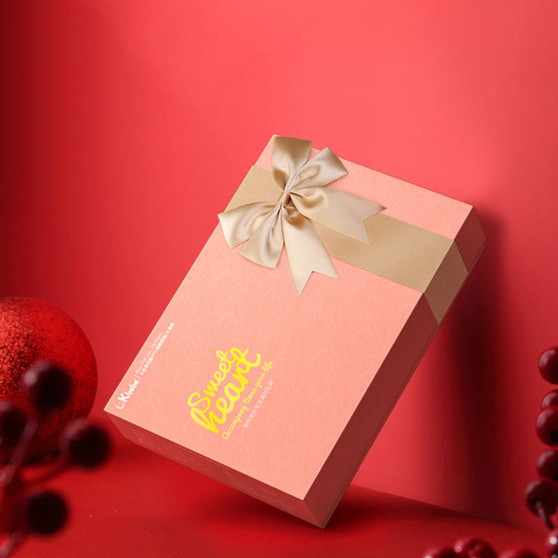 Pink gift box with a gold bow on a red background