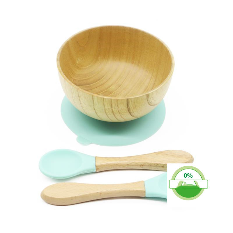 Wooden bowl and spoons with green accents on a white background