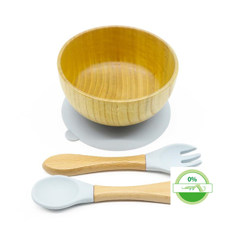 Set of wooden bowls and utensils with silicone handles on a white background