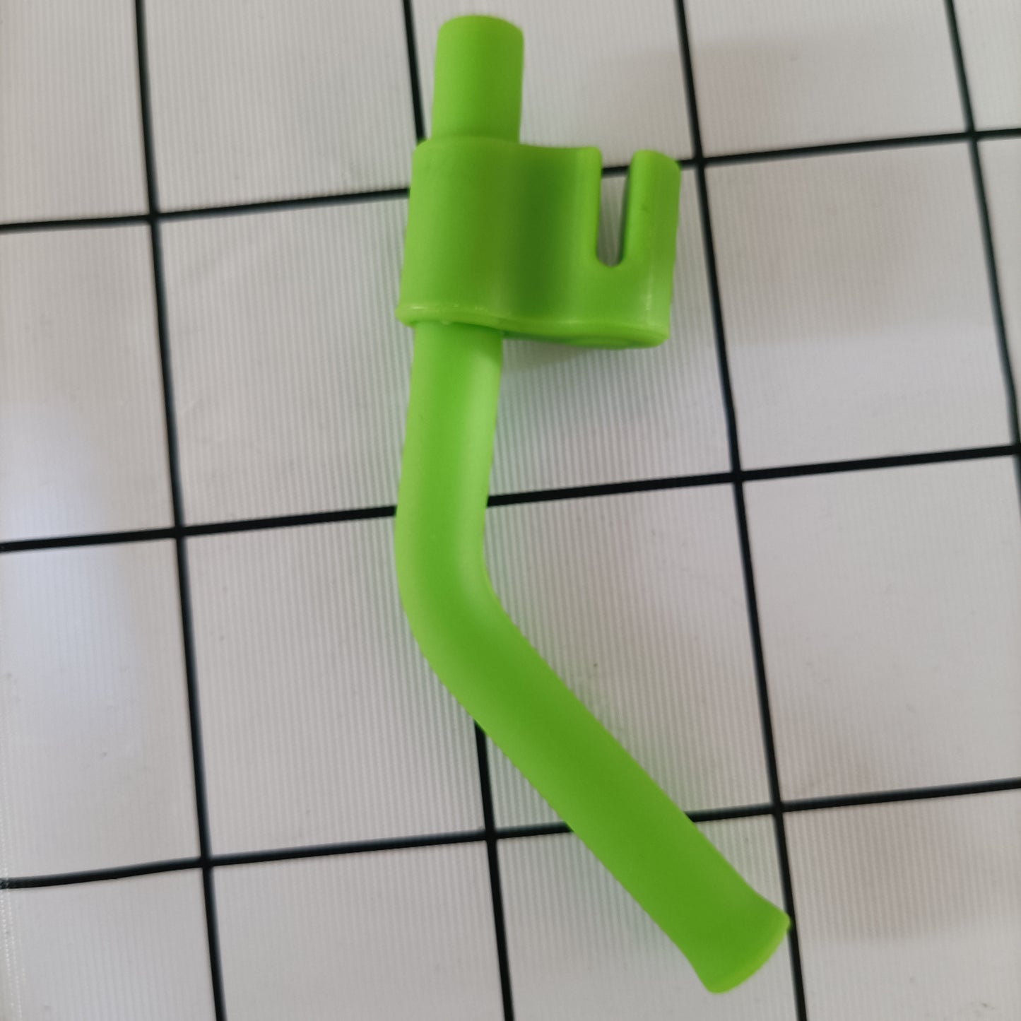 Green plastic component on a grid background