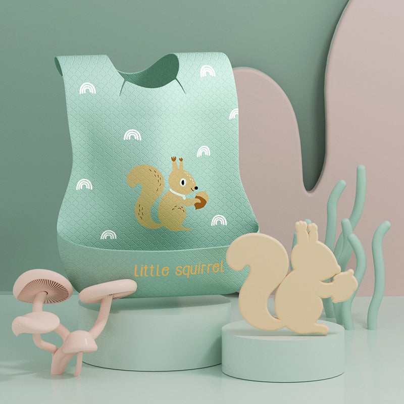 Green bib with squirrel design and small squirrel figurine on a light green background