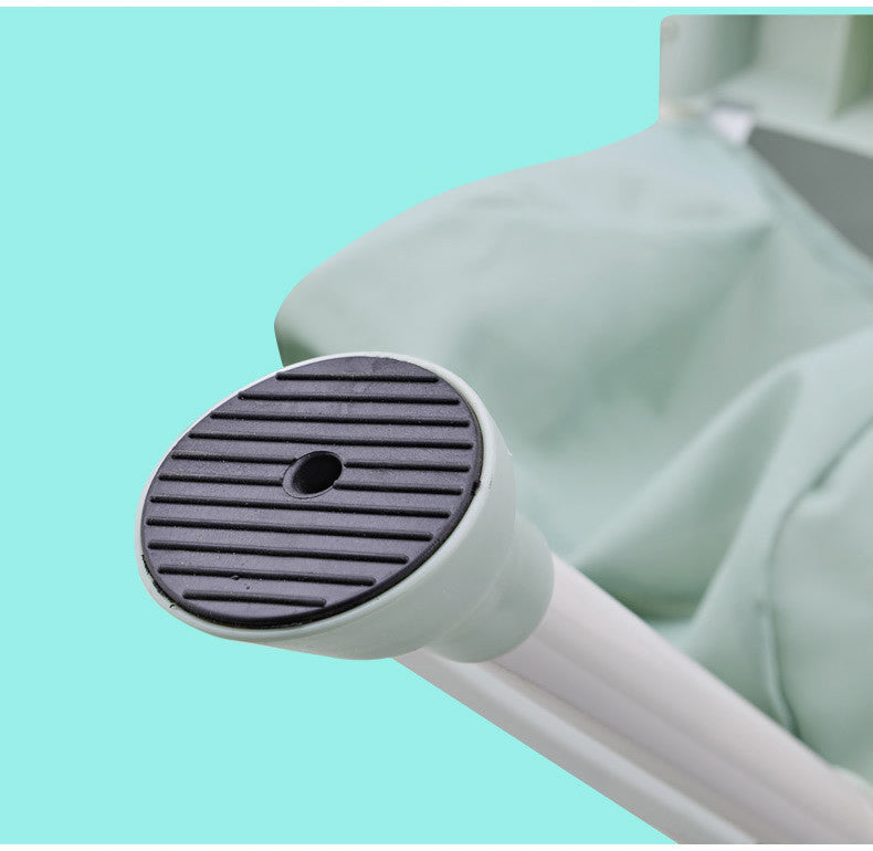 Close-up of a green cleaning tool with a black bristle brush on a light blue background
