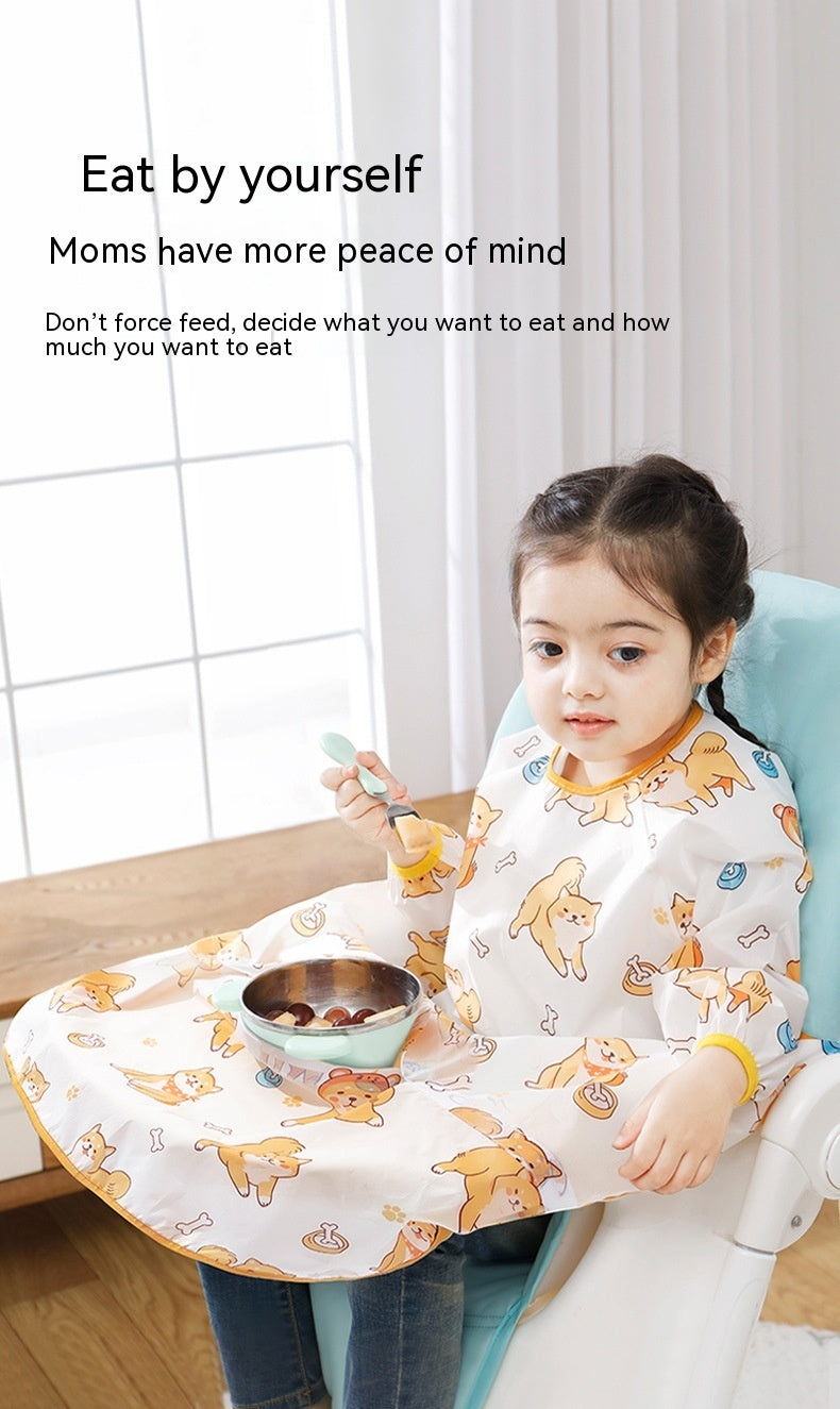 Child wearing a bib with animal patterns, sitting at a table with a bowl and spoon.