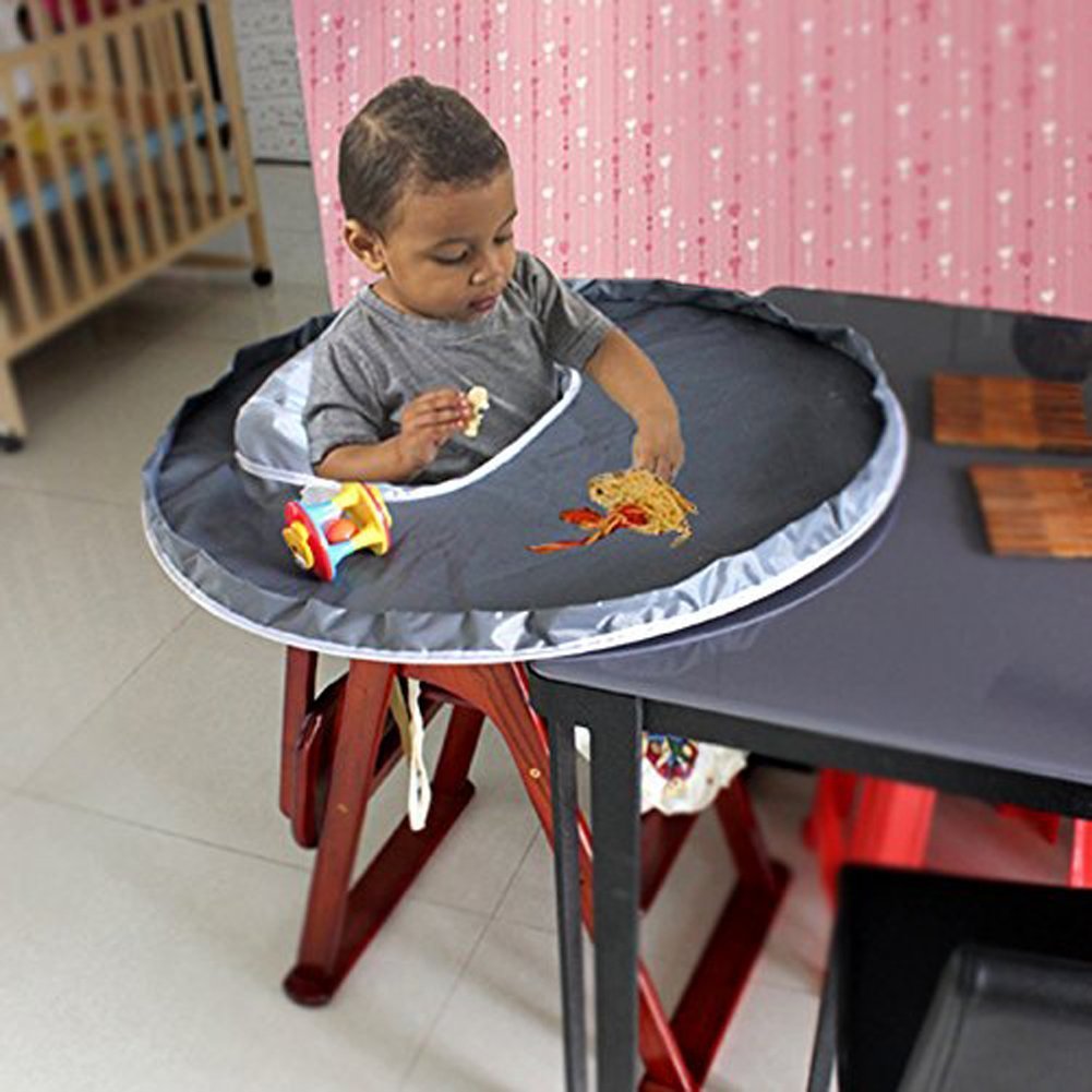 Child sitting at a table with a portable dining setup, eating noodles.
