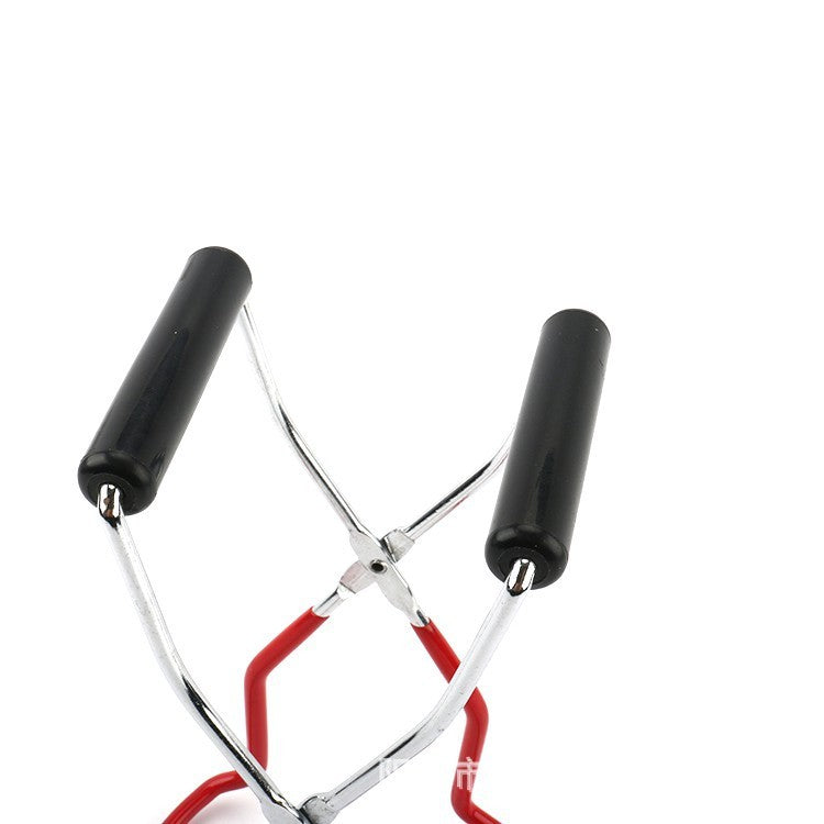 Metallic eyelash curler with black handles on a white background
