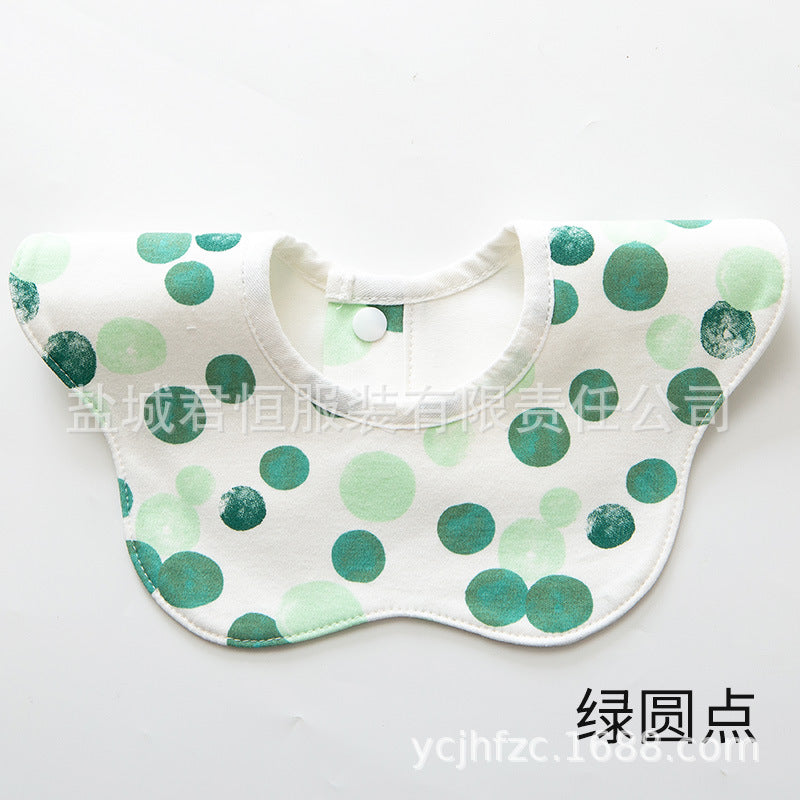 Baby bib with green polka dot pattern on a white background