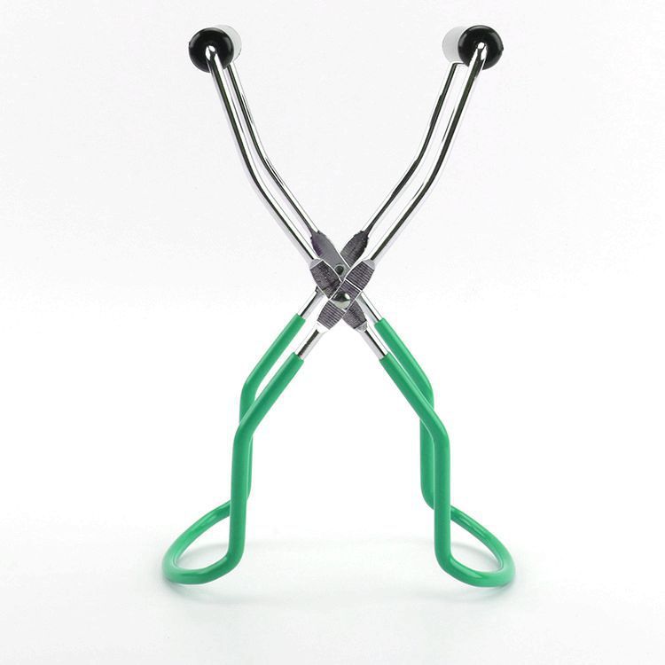 Green tongs with metal handles on a white background