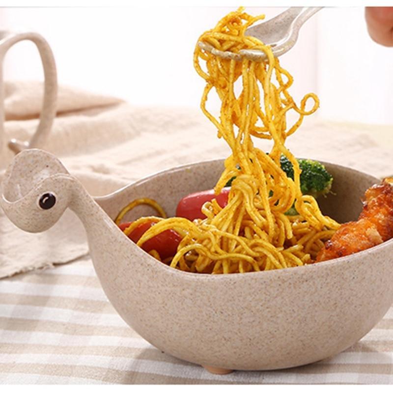 Noodles being lifted from a bowl with a turtle design on a striped tablecloth.