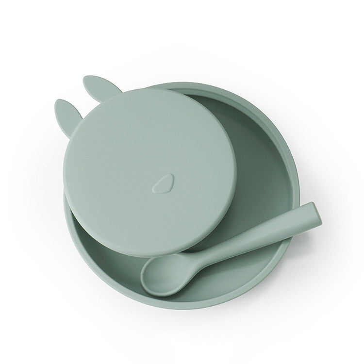 Mint green children's bowl with lid and spoon on a white background