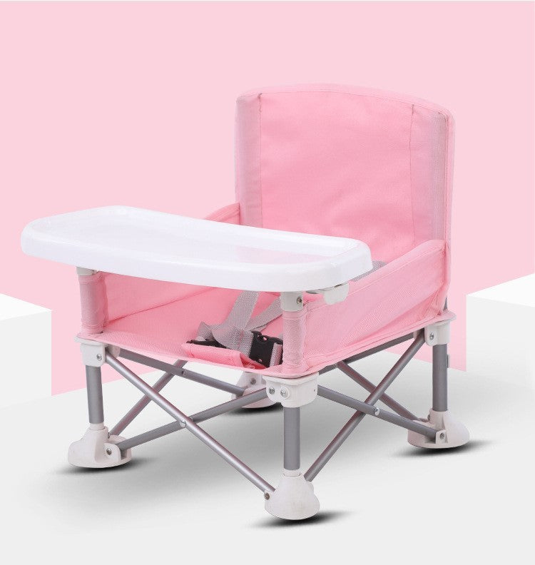 Pink and white folding chair with a tray on a light pink background