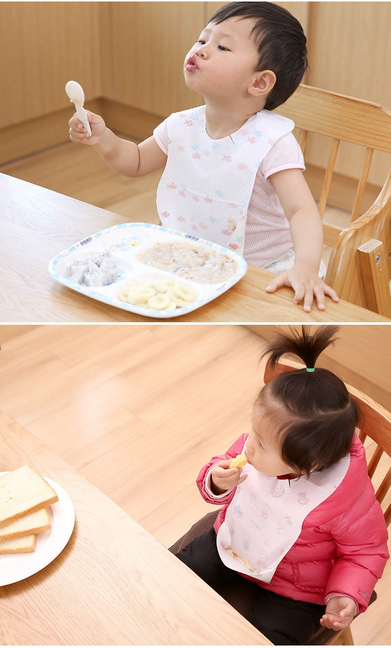 Two children at a dining table with plates of food and utensils.