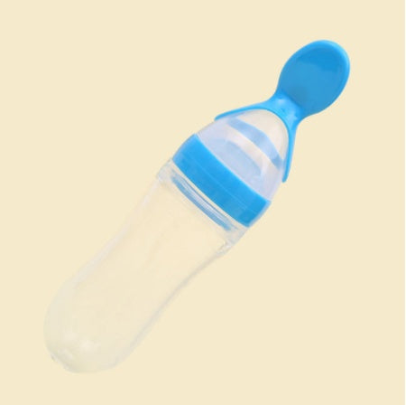 Blue baby bottle with spoon on a beige background