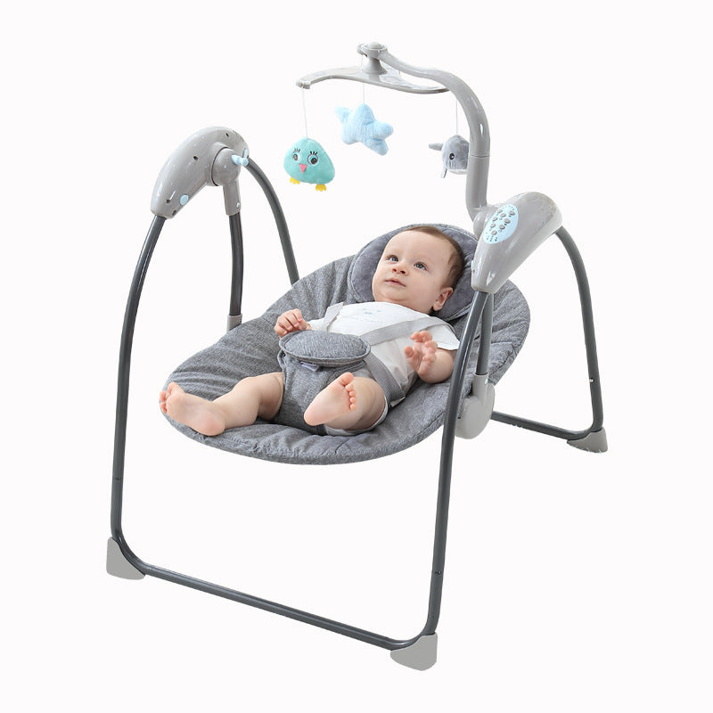 Baby in a gray baby swing with toys on a white background