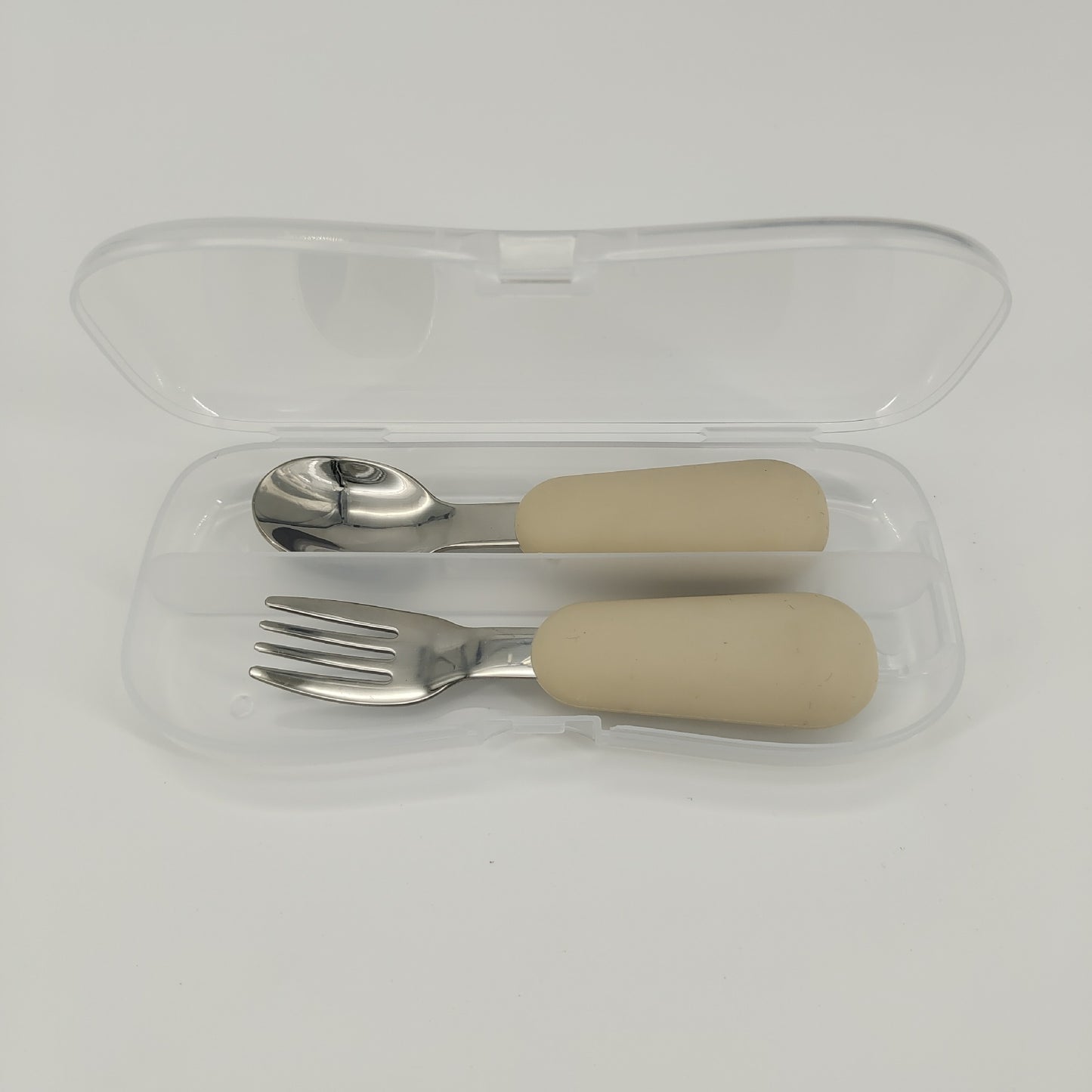 Set of silver cutlery with beige handles in a clear case on a white background