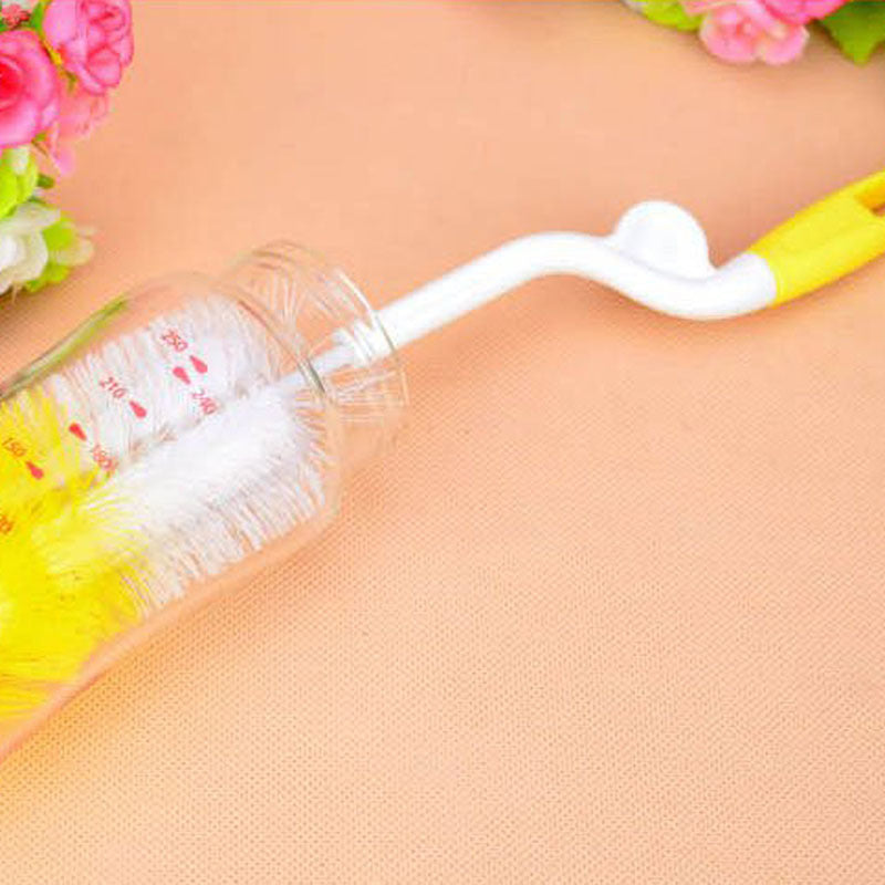 Bottle brush with a clear container on a peach-colored surface with floral decorations.