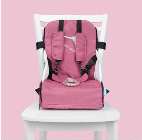 Pink high chair cover with black straps on a white chair against a pink background