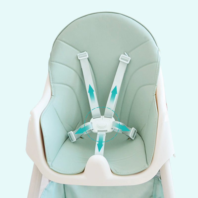 Baby seat with green cushion and straps on a light blue background