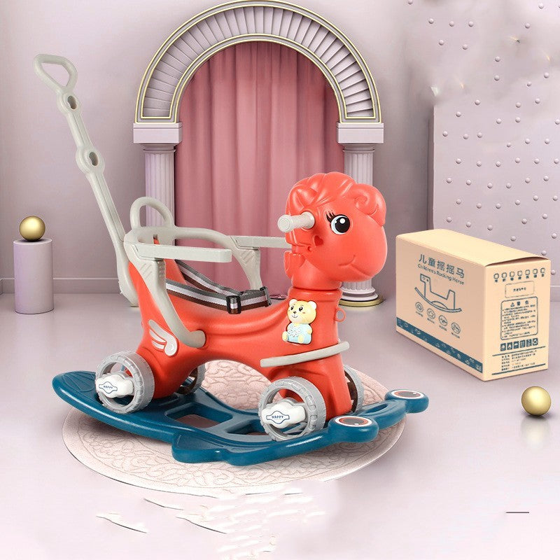 Red rocking horse toy with wheels on a white surface, with a box in the background.