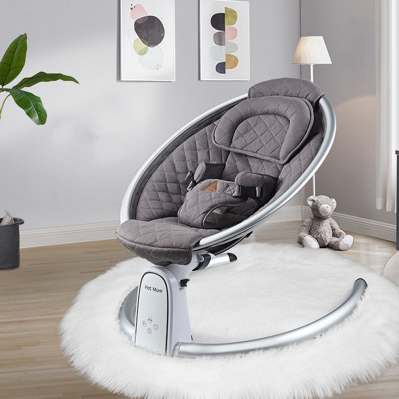 Gray baby swing chair in a room with a teddy bear and plant decor.